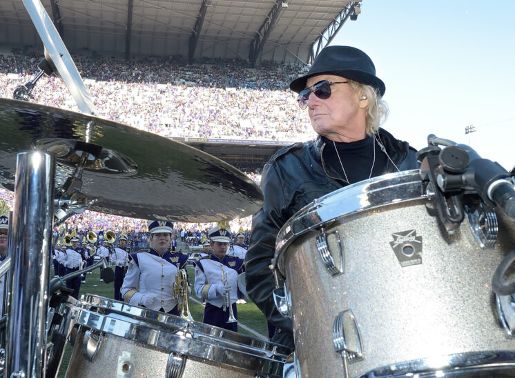Alan White, world-class drummer for YES, John Lennon/Imagine, George Harrison/My Sweet Lord, and Rock and Roll Hall of Fame inductee being honored by the UW Husky Marching Band during their halftime show. © Jerry and Lois Photography