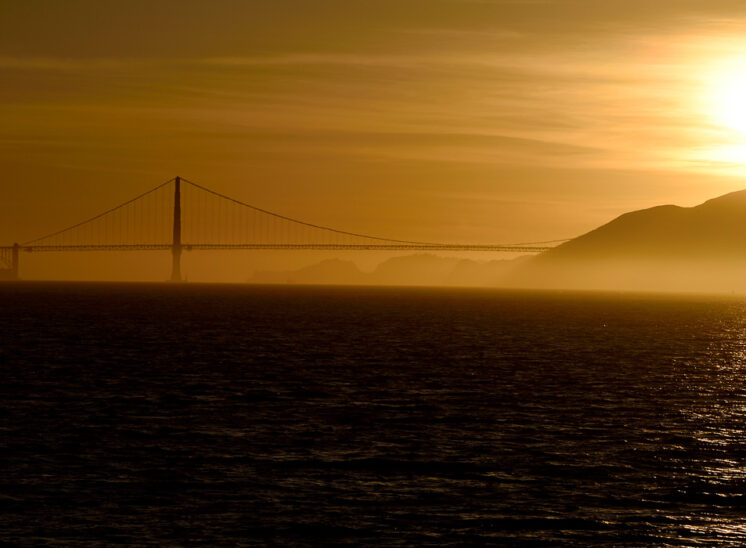 A fabulous sunset silhouettes the Golden Gate Bridge, the S.F. Bay and the North Bay mountains, all painted in golden tones. Jerry and Lois Photography
